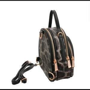 A mini black leopard leather backpack .